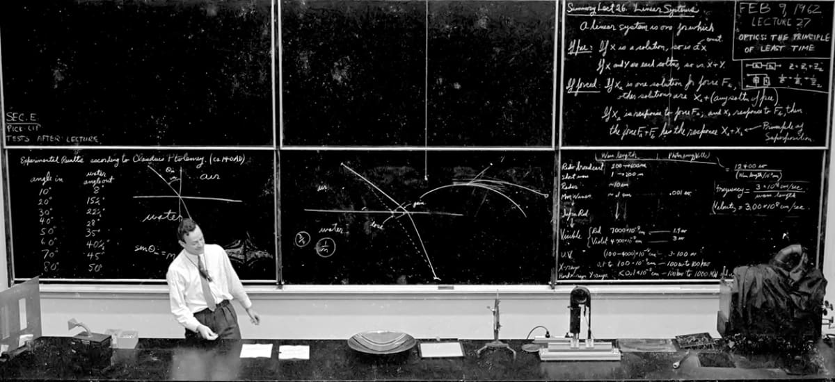 Richard Feynman lecturing at Caltech, February 9, 1962, standing before chalkboards filled with optics equations, Ptolemy's refraction data, and the principle of superposition.