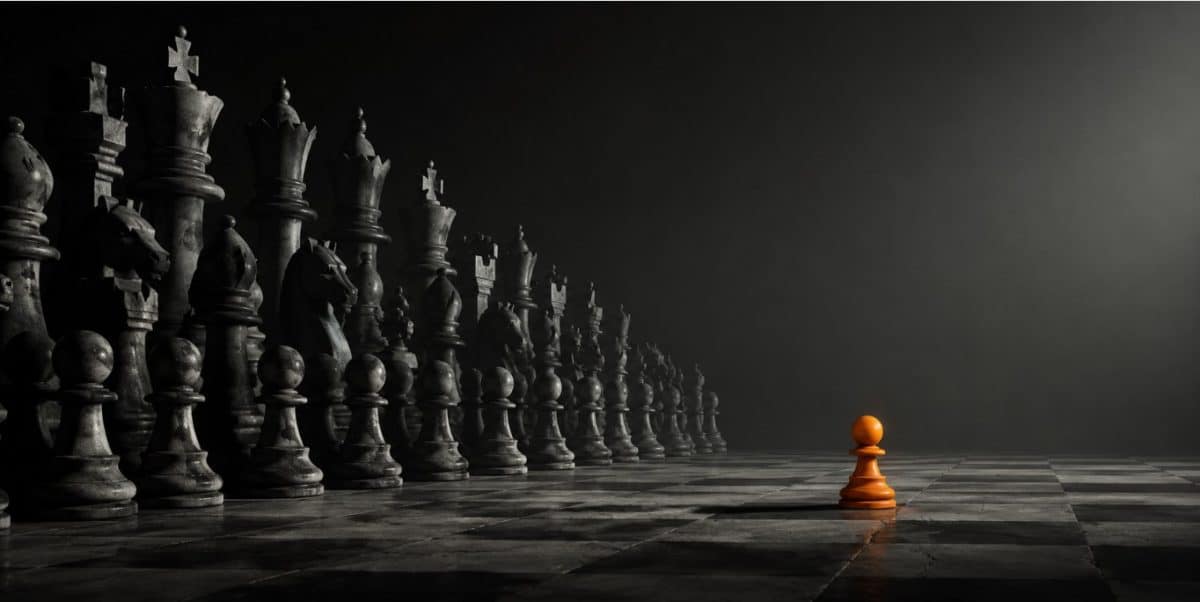 A lone orange pawn faces a massive wall of gray stone chess pieces on a dark board, one small operator against the institutions.