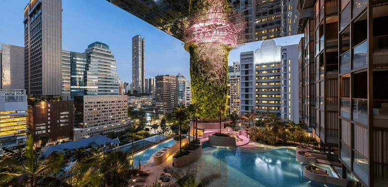 Luxury hotel rooftop pool overlooking a modern city skyline at dusk, reflecting calm, design-driven hospitality aesthetics.