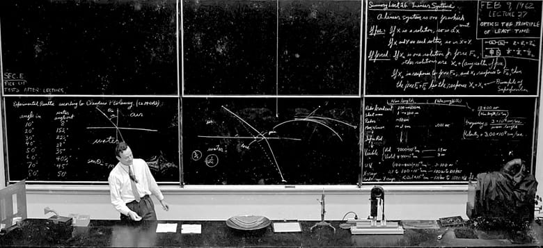 Richard Feynman lecturing at Caltech, February 9, 1962, standing before chalkboards filled with optics equations, Ptolemy's refraction data, and the principle of superposition.