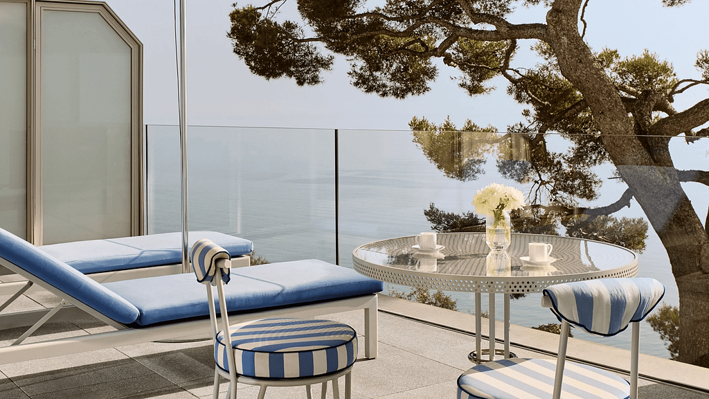 Minimalist luxury hotel terrace overlooking the sea, emphasizing calm, space, and visual focus in high-end design.
