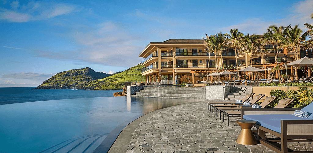 Infinity-style pool at Andiamo luxury villa with lake views, surrounded by lounge seating and a peaceful natural landscape.