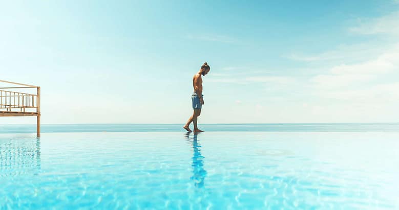 Luxury resort infinity pool overlooking the ocean, symbolizing a continuous guest journey and long-term relationships