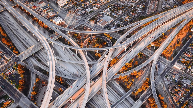 Aerial view of a complex highway interchange symbolizing the layered infrastructure behind how travel demand flows through modern hospitality distribution systems.