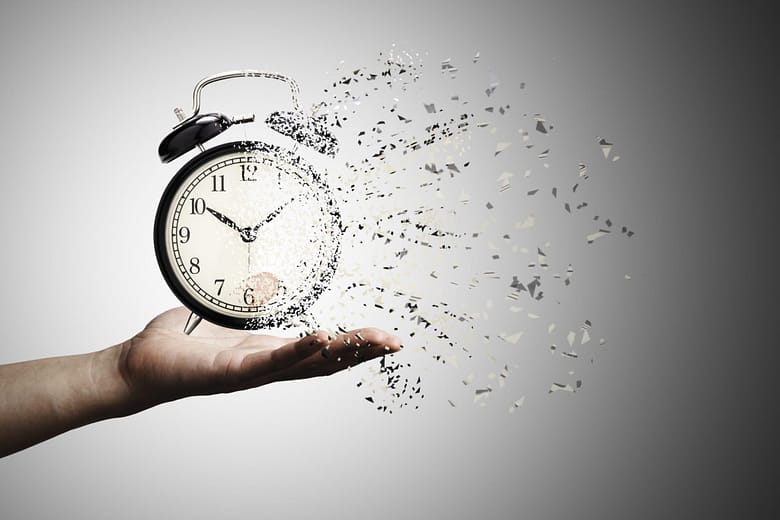 alarm clock disintegrating in a person's hand symbolizing time repeating and the recurring problems luxury hotel marketers face when new clients call