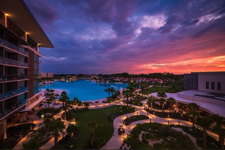 Luxury resort property at sunset with pool and grounds illuminated, representing the visible success that masks hidden OTA commission losses in luxury hotel demand economics.