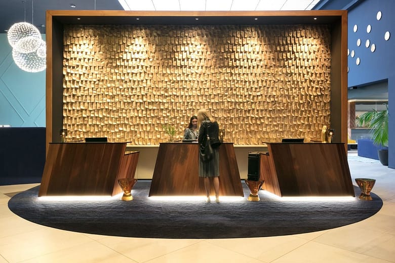 Guest checking in at a hotel reception desk, representing the process of converting traveler interest into hotel bookings.