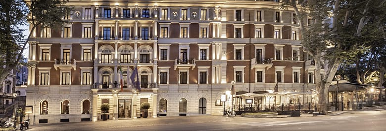 InterContinental Rome Ambasciatori Palace illuminated at dusk on Via Veneto, representing luxury hotels competing for visibility in modern travel discovery systems