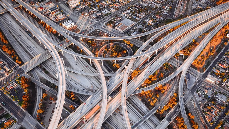 Aerial view of a complex highway interchange symbolizing the layered infrastructure behind how travel demand flows through modern hospitality distribution systems.