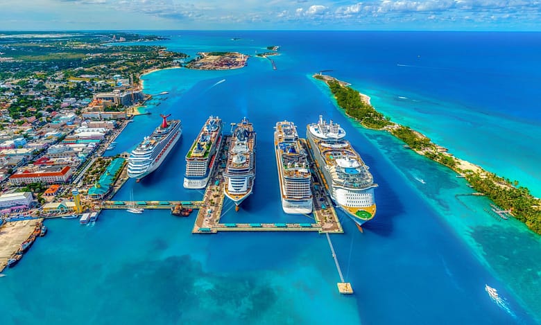 Cruise ships docked at a Caribbean cruise port viewed from above, illustrating the scale and capacity of the modern cruise industry.