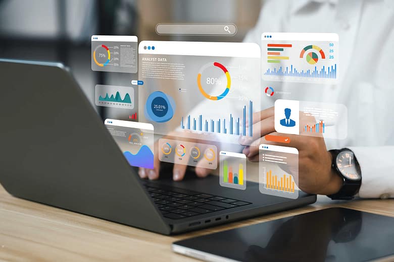 Person using a laptop with multiple floating analytics dashboard panels showing charts, graphs, and performance metrics overlaid on the screen.