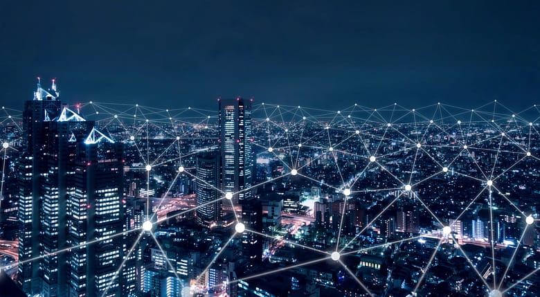 City skyline at night with a digital network of connected nodes and lines representing the flow and formation of knowledge across AI systems.