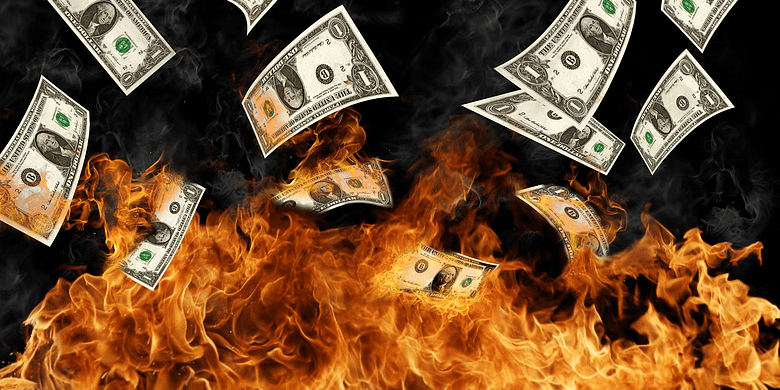 U.S. dollar bills burning in flames, symbolizing revenue lost to OTA commissions and margin erosion in luxury hotel distribution.